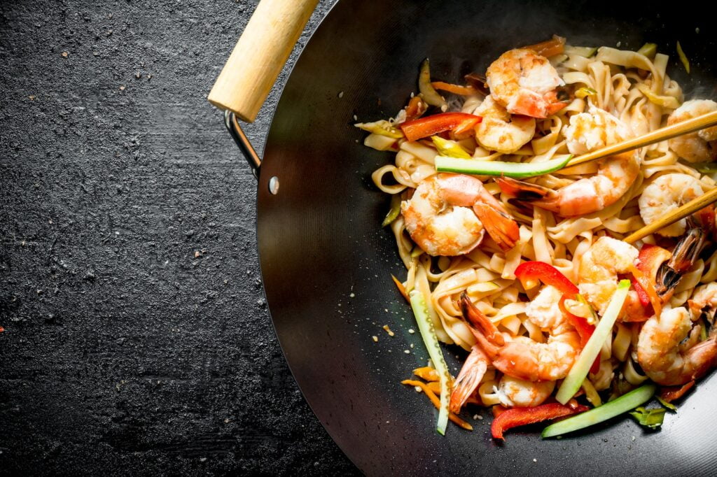 Fragrant Asian Udon noodles in a wok pan.