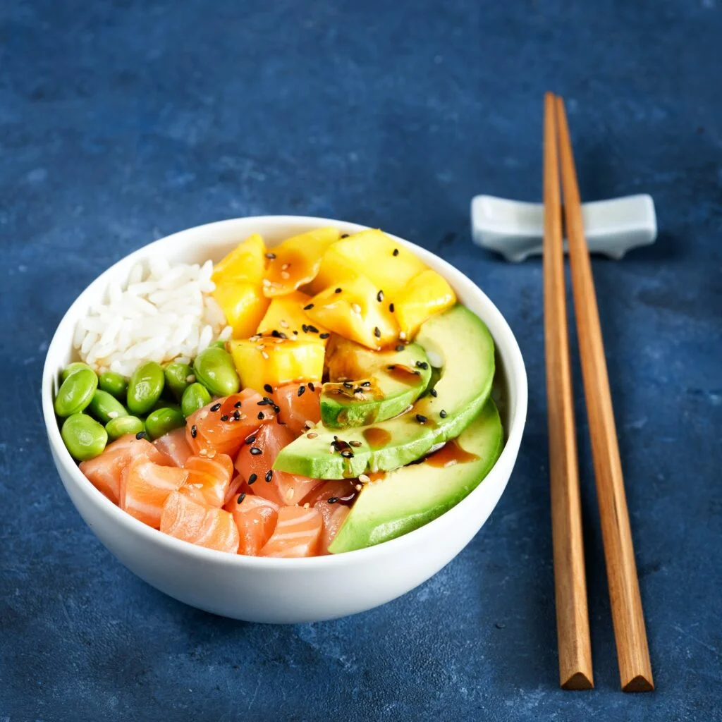 Salmon Poke bowl Raw fish salad Asian trendy food, mango, soy beans edamame, rice.